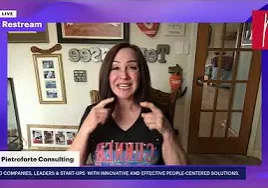 Woman in a shirt on a TV screen, and giving a thumbs up