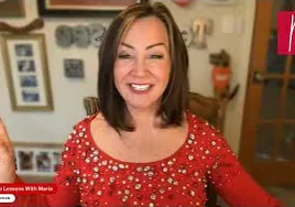 Smiling woman in red top points up